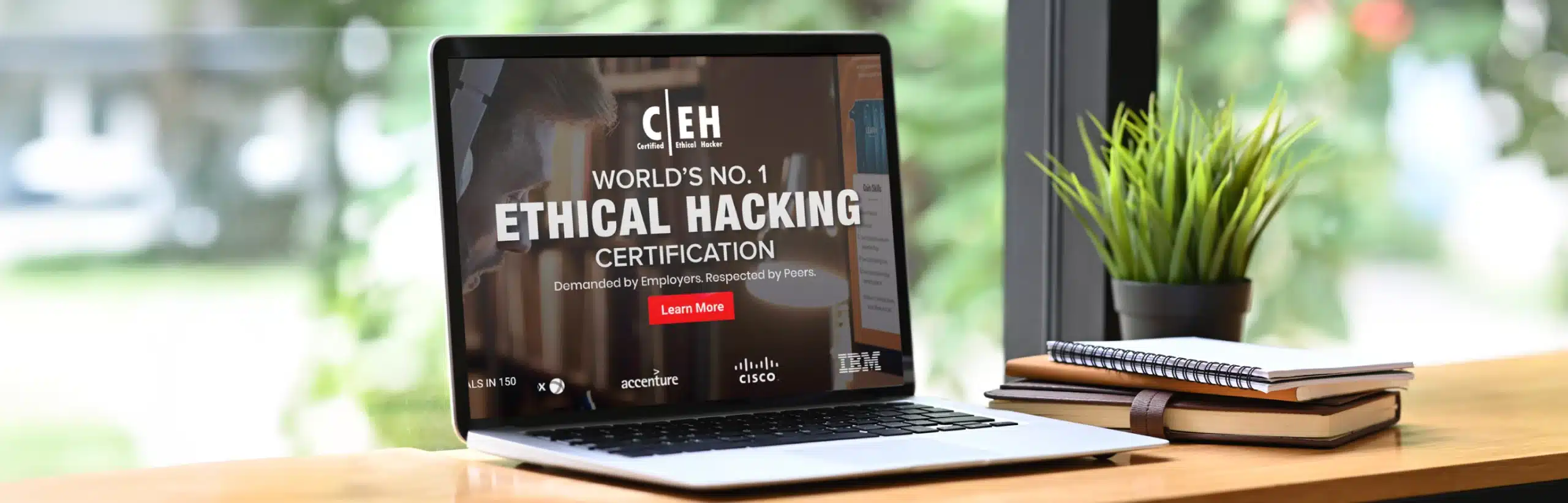 Laptop Displaying ‘ceh World’s No. 1 Ethical Hacking Certification’ Ad, With Plant And Notebooks